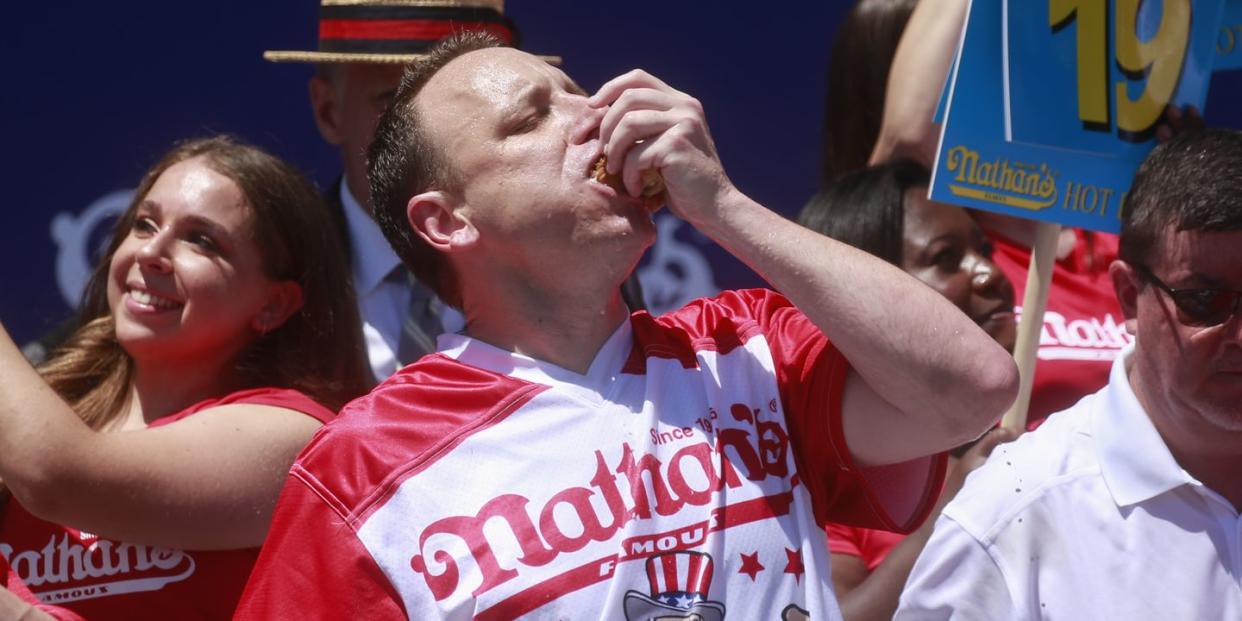 joey chestnut stuffing his mouth with hot dogs during an eating competition