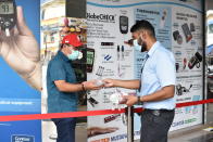 A security guard hands out disposable gloves to a man outside the supermarket section of the Mustafa Center on Saturday, May 16, 2020 in Singapore’s Little India district. Singapore has reported more than 27,000 COVID-19 cases, with 90% of the cases linked to foreign workers dormitories, but it has a low fatality rate of 21 deaths. (AP Photo/YK Chan)