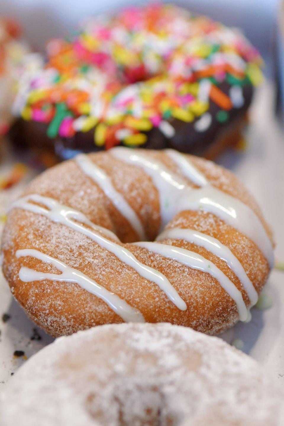 A Candied Lime doughnut, one of the seasonal offerings at Duck Donuts, is nestled between other doughnut selections.