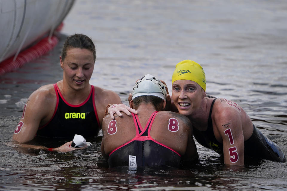 Gold medalist Ana Marcela Cunha, center, of Brazil, is hugged by bronze medal winner Kareena Lee, right, of Australia, after the women's marathon swimming competition at the 2020 Summer Olympics, Wednesday, Aug. 4, 2021, in Tokyo, Japan. At left is Germany's Leonie Beck who placed fifth. (AP Photo/Jae C. Hong)