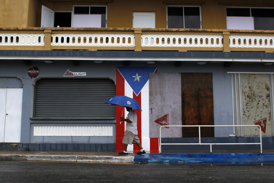 A man with an umbrella walks on a sidewalk as Hurricane Irma approaches Puerto Rico in Luquillo, on September 6, 2017. Irma is expected to reach the Virgin Islands and Puerto Rico by nightfall on September 6.  / AFP PHOTO / Ricardo ARDUENGO        (Photo credit should read RICARDO ARDUENGO/AFP/Getty Images)