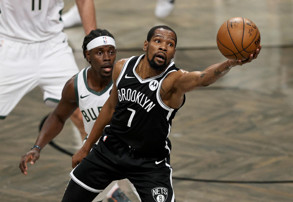 Kevin Durant #7 of the Brooklyn Nets grabs the loose ball as Jrue Holiday #21 of the Milwaukee Bucks defends in the first half during game seven of the Eastern Conference second round at Barclays Center on June 19, 2021 in the Brooklyn borough of  New York City. NOTE TO USER: User expressly acknowledges and agrees that, by downloading and or using this photograph, User is consenting to the terms and conditions of the Getty Images License Agreement. (Photo by Elsa/Getty Images)