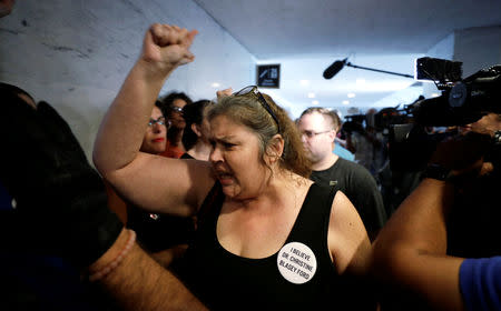 A protester voices opposition to U.S. President Donald Trump's Supreme Court nominee Brett Kavanaugh and her support for Dr. Christine Blasey Ford, the woman who has accused Kavanaugh of sexual assault, during a demonstration on Capitol Hill in Washington, U.S., September 20, 2018. REUTERS/Yuri Gripas