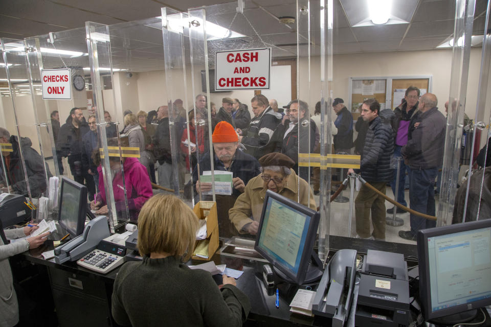 <strong>People line-up at the Town of Hempstead tax receiver’s office to pay their real estate taxes before the end of the year, hoping for one last chance to take advantage of a major tax deduction before it is wiped out in the new year. (Howard Schnapp/Newsday via AP)</strong>