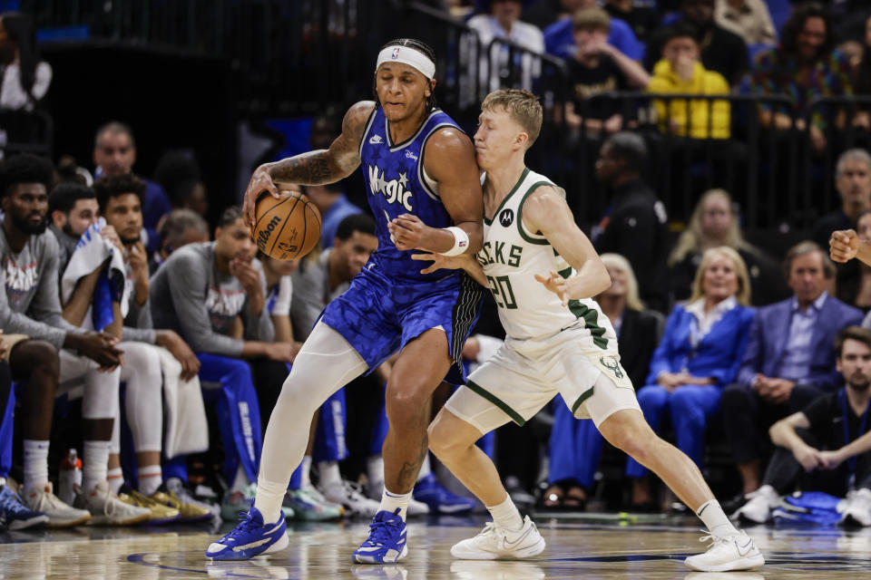 Orlando Magic forward Paolo Banchero, left, is defended by Milwaukee Bucks guard AJ Green during the second half of an NBA basketball game Saturday, Nov. 11, 2023, in Orlando, Fla. (AP Photo/Kevin Kolczynski)