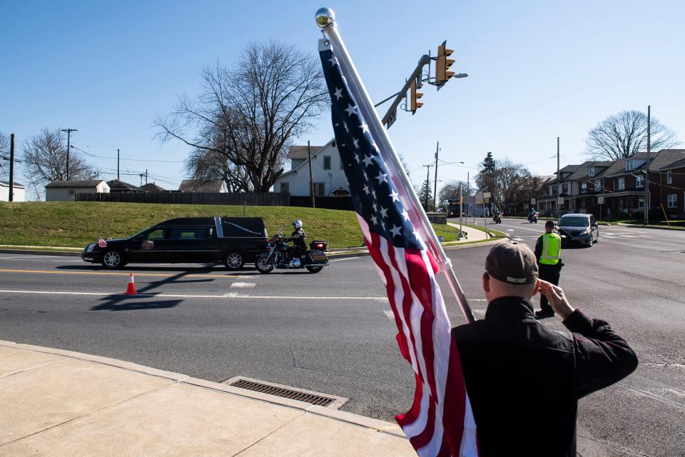 Thom Iriana, of Hershey, salutes as the hearse carrying the body of Lebanon City Police Lt. William Lebo turns onto N. Lingle Avenue during a funeral procession from Lebanon to Hershey on Friday, April 8, 2022, in Derry Township. 