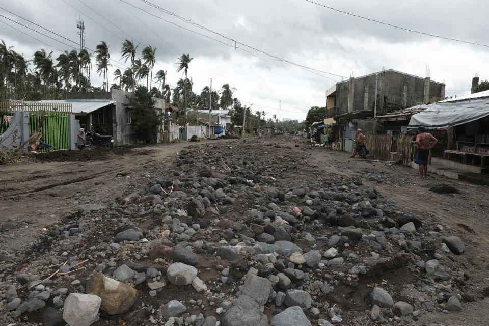 Boulders and mudflows from Mayon Volcano triggered by heavy rains from Typhoon Goni are seen along a street in the town of Guinobatan, Albay province, central Philippines on Monday, Nov. 2, 2020. More than a dozen of people were killed as Typhoon Goni lashed the Philippines over the weekend, and about 13,000 shanties and houses were damaged or swept away in the eastern island province that was first hit by the ferocious storm, officials said Monday. (AP Photo/John Michael Magdasoc)