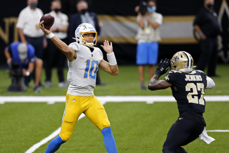 Los Angeles Chargers quarterback Justin Herbert (10) passes under pressure from New Orleans Saints strong safety Malcolm Jenkins (27) in the first half of an NFL football game in New Orleans, Monday, Oct. 12, 2020. (AP Photo/Brett Duke)