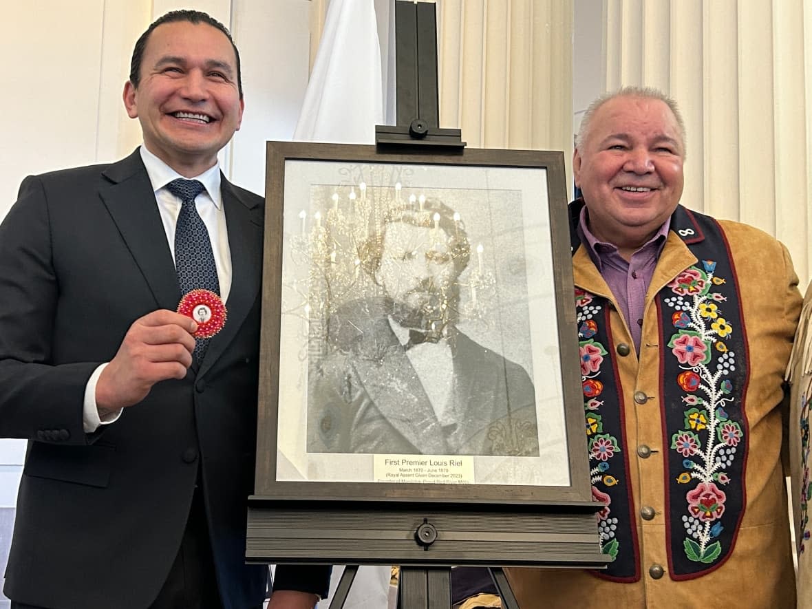 Manitoba Premier Wab Kinew, left, and Manitoba Métis Federation President David Chartrand unveiled a new plaque for Louis Riel's portrait at the legislature on Monday. (Gilbert Rowan/Radio-Canada - image credit)