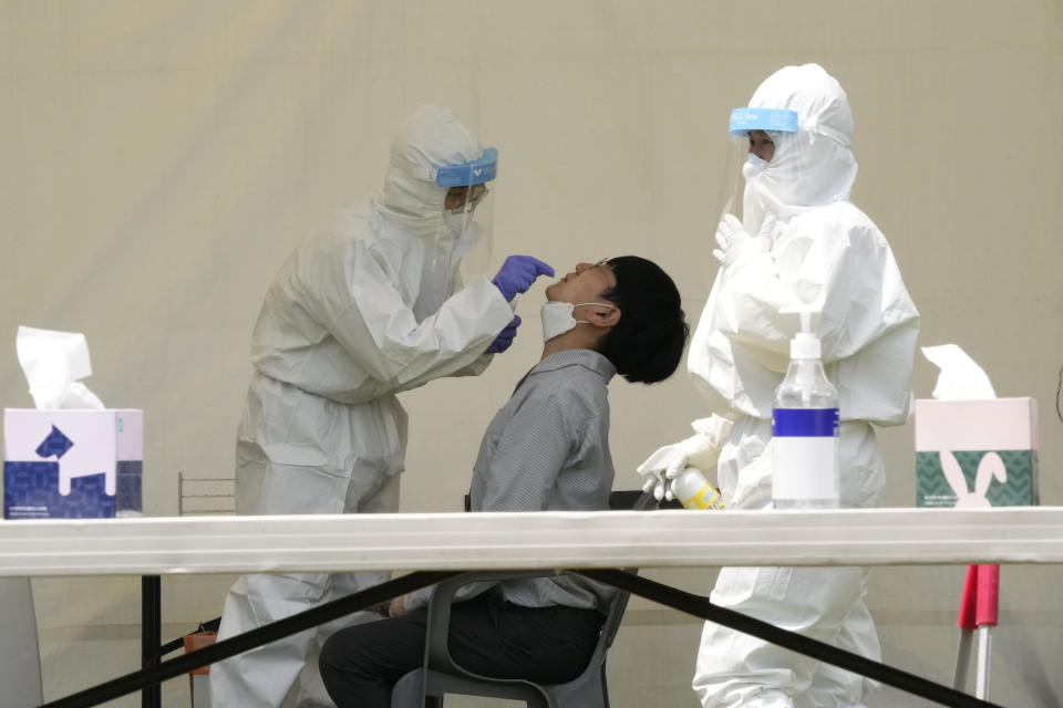 A medical worker takes a nasal sample from a man during a COVID-19 testing at a makeshift testing site at the National Assembly in Seoul, South Korea, Thursday, July 15, 2021. South Korea has added 1,600 more coronavirus cases, with infections spreading beyond the hard-hit capital area where officials have enforced the country's toughest social distancing restrictions. (AP Photo/Ahn Young-joon)