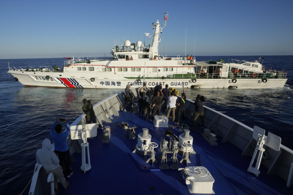 Journalists report as a Chinese coast guard ship blocks the path of Philippine coast guard BRP Sindangan as they tried to enter the Second Thomas Shoal, locally known as Ayungin Shoal, in the disputed South China Sea Tuesday, March 5, 2024. Chinese and Philippine coast guard vessels collided in the disputed South China Sea and multiple Filipino crew members were injured in high-seas confrontations Tuesday as Southeast Asian leaders gathered for a summit that was expected to touch on Beijing's aggression at sea. (AP Photo/Aaron Favila)