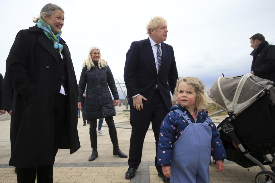 Britain's Prime Minister Boris Johnson, centre, talks to a member of the public as he campaigns on behalf of Conservative Party candidate Jill Mortimer, left, in Hartlepool, England, Monday, May 3, 2021, ahead of the 2021 Hartlepool by-election to be held on May 6. (Lindsey Parnaby/PA via AP)