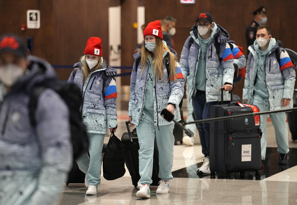 Members of the Russian Olympic Committee team walk before their departure for the 2022 Winter Beijing Olympic Games in Moscow's Sheremetyevo airport, Russia, Wednesday, Jan. 26, 2022. (AP Photo/Pavel Golovkin)