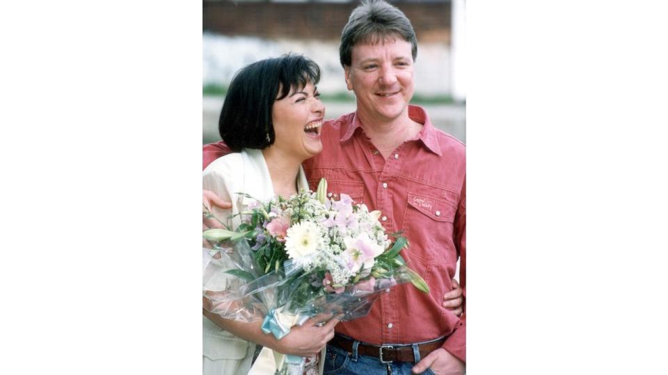 Lorraine Kelly in a white jacket laughing at her husband Steve Smith