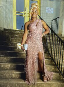 A girl stands in her prom dress