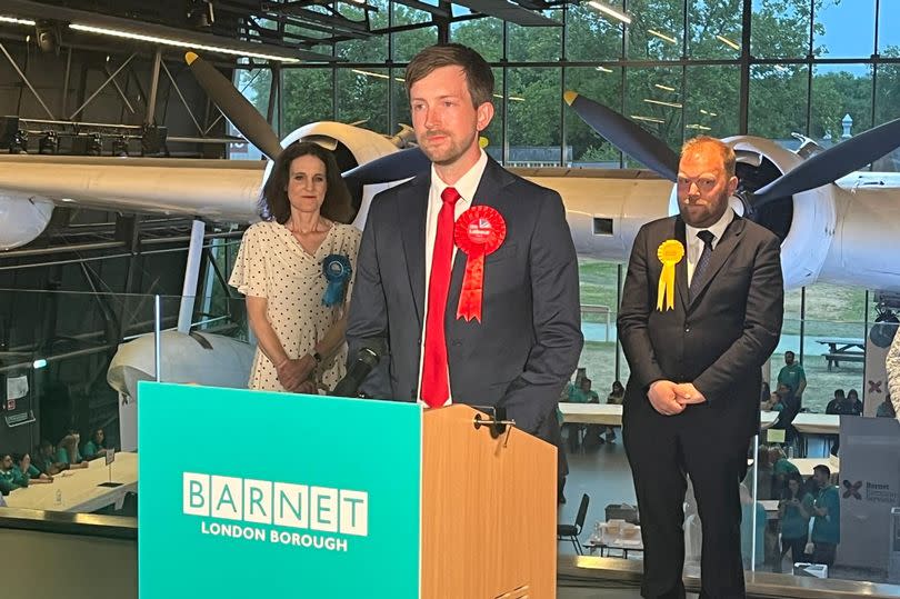 Dan Tomlinson at lectern delivering victory speech