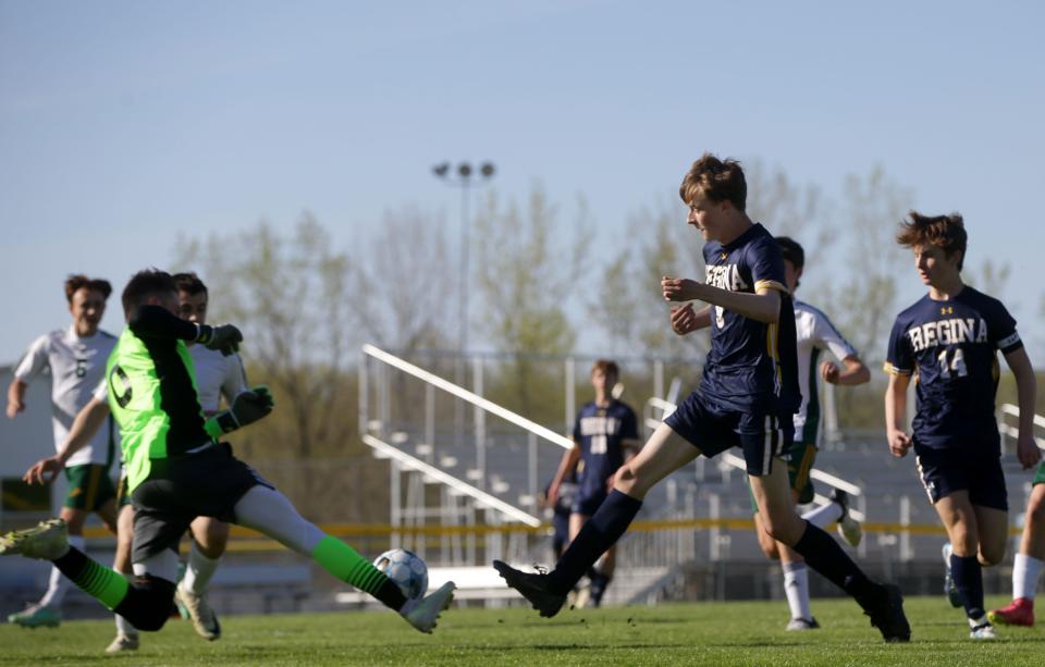 Regina Catholic’s Thor Olso (9) tries to tap the ball past Beckman Catholic’s goalie on April 24 in Iowa City.