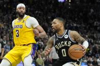 Los Angeles Lakers' Anthony Davis tries to stop Milwaukee Bucks' Damian Lillard during overtime of an NBA basketball game Tuesday, March 26, 2024, in Milwaukee. The Lakers won 128-124 in double overtime. (AP Photo/Morry Gash)