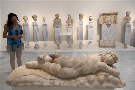 A tourist looks at a statue of a sleeping Maenad (AD 117-138) in the National Archaeological museum in Athens August 22, 2013. REUTERS/John Kolesidis