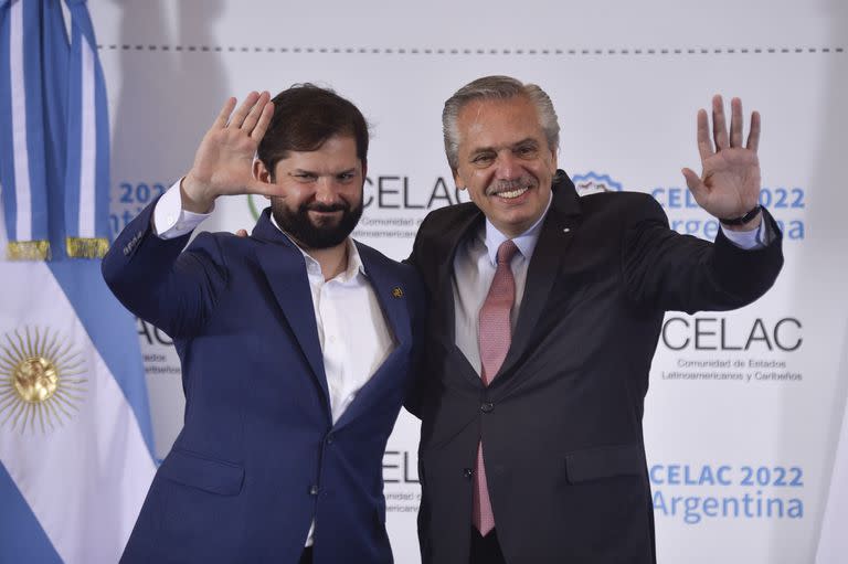 El presidente de Chile, Gabriel Boric y el presidente de Argentina, Alberto Fernández, saludan a los periodistas durante la Cumbre de la Comunidad de Estados Latinoamericanos y Caribeños (CELAC) en Buenos Aires