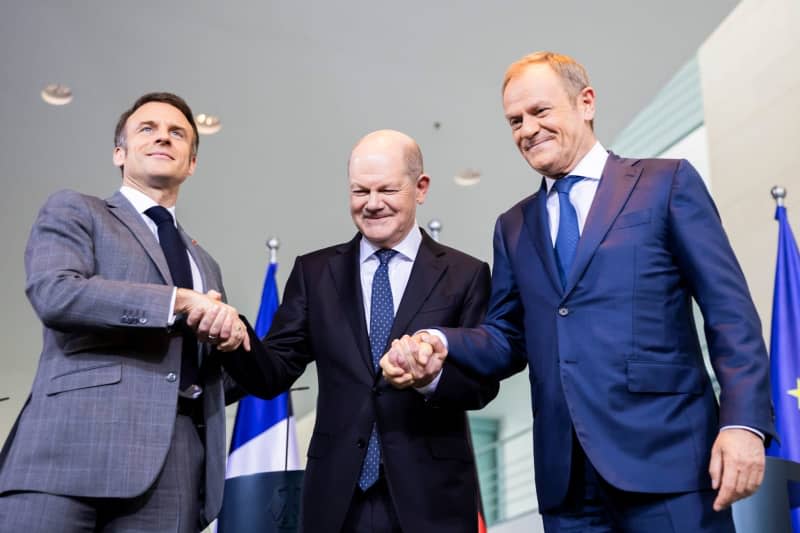 German Chancellor Olaf Scholz (C) poses for a picture with French President Emmanuel Macron (L) and Polish Prime Minister Donald Tusk during a press statement after the so-called Weimar Triangle meeting. Christoph Soeder/dpa