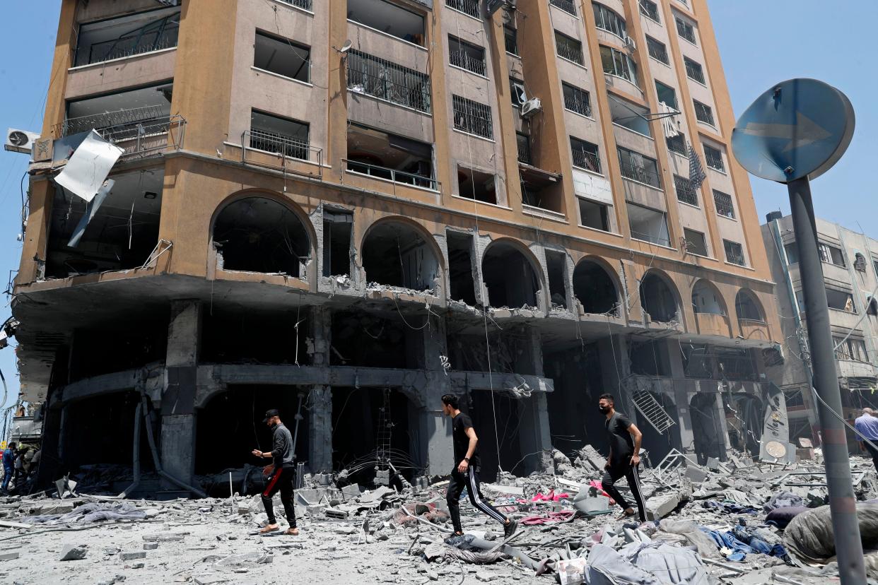 People inspect the rubble of a damaged building that was hit by an Israeli airstrike, in Gaza City, Wednesday, May 12, 2021.