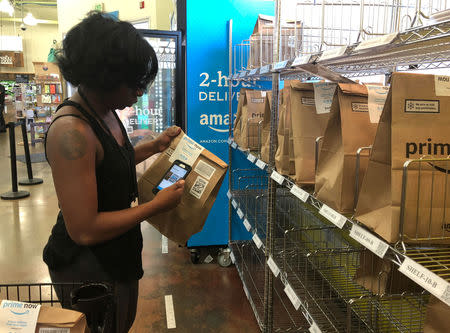 A Whole Foods shopper prepares a delivery order at the grocer's Rockwood Commons store in Cincinnati, Ohio, June 28, 2018. Picture taken June 28, 2018. REUTERS/Lisa Baertlein