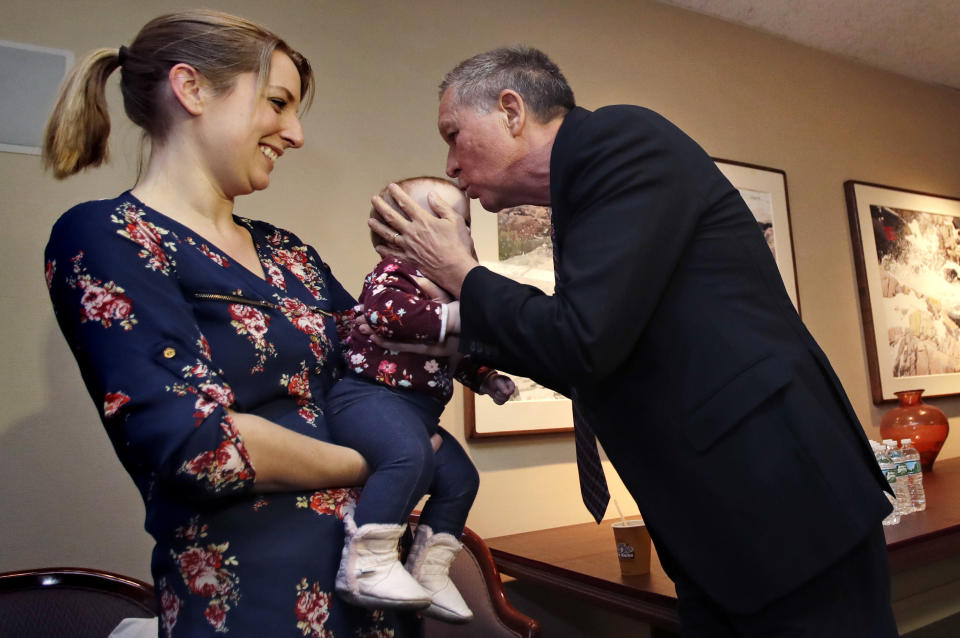 Ohio Gov. John Kasich, a potential 2020 Presidential candidate, kisses the forehead of eight-month-old Cora, of Fremont, N.H. while being held by her mother Jessica in Concord, N.H., Thursday, Nov. 15, 2018. The visit marked Gov. Kasich's second trip to the state this year. (AP Photo/Charles Krupa)