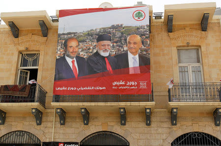 A poster of Samir Geagea, leader of the Christian Lebanese Forces, former Lebanon's Christian Maronite Patriarch Mar-Nasrallah Boutros Sfeir and Lebanese parliament candidate Georges Aqeis hangs on a building in the city of Zahle, Lebanon May 4, 2018. REUTERS/Aziz Taher