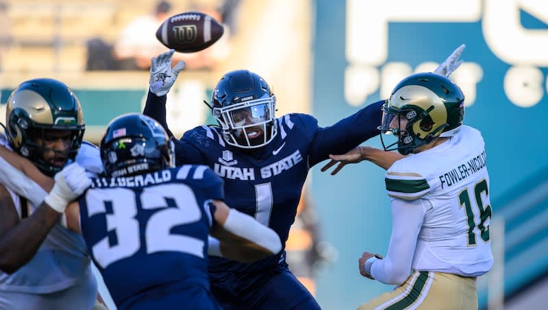 Colorado State quarterback Brayden Fowler-Nicolosi (16) throws the ball away before being tackled by Utah State safety Anthony Switzer (1) during a game on Saturday, Oct. 7, 2023 in Logan, Utah.
