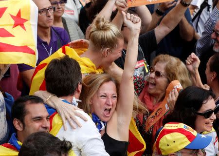 People react as they watch on giant screens a plenary session outside the Catalan regional parliament in Barcelona, Spain, October 27, 2017. REUTERS/Yves Herman TPX IMAGES OF THE DAY