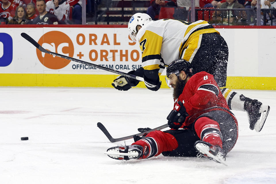 Pittsburgh Penguins' Bryan Rust (17) collides with Carolina Hurricanes' Brent Burns (8) during the first period of an NHL hockey game in Raleigh, N.C., Sunday, Dec. 18, 2022. (AP Photo/Karl B DeBlaker)