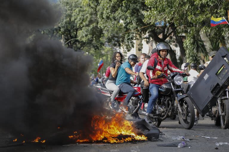 Manifestantes protestan contra los resultados oficiales de las elecciones que declaran que el presidente Nicolás Maduro ganó la reelección en el barrio de Catia de Caracas, Venezuela, el lunes 29 de julio de 2024, un día después de la votación