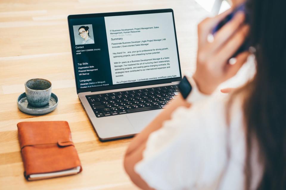 a young woman looking at her cv on a laptop