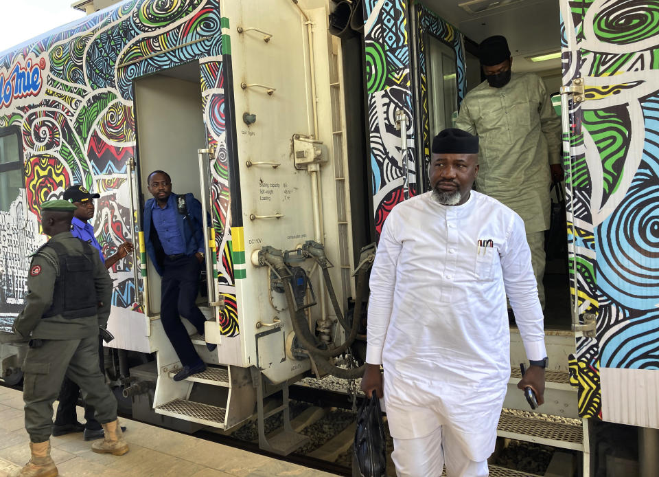 Passengers disembark from a train at the train station in Abuja, Nigeria, Monday, Dec. 5, 2022. Train service in Nigeria's capital city resumed on Monday, eight months after assailants attacked a train with explosives and gunfire, killing seven people and abducting dozens of passengers. (AP Photo/Chinedu Asadu)