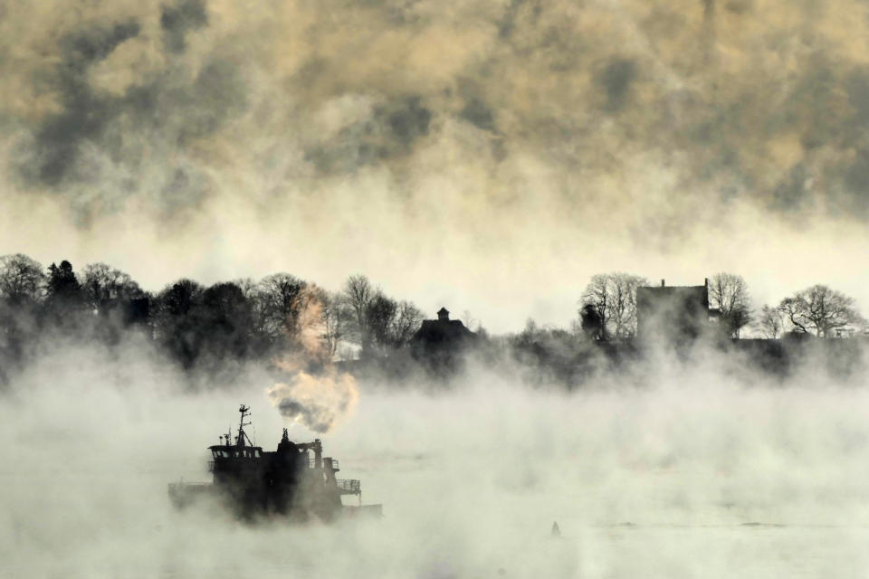 Arctic sea smoke rises from the the Atlantic Ocean as a passenger ferry passes House Island Saturday, Feb. 4, 2023, off the coast of Portland, Maine. The morning temperature was about -10 degrees Fahrenheit. (AP Photo/Robert F. Bukaty)
