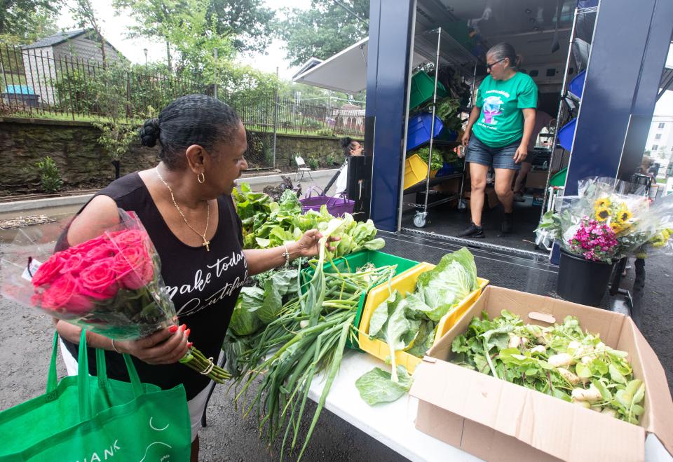 Rita Echevarria, 72, of New Rochelle, selects produce at the Grow! Eat food distribution truck July 14, 2023. Grow! Eat distributes food throughout New Rochelle as part of an effort to alleviate food insecurity. Grow! Eat partners with Meals on Main Street, another local non-profit that works to eradicate food insecurity. 