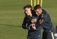 Phlippe Coutinho, left, is embraced by Casemiro during a training session of Brazil national soccer team in Porto Alegre, Brazil, Wednesday, June 26, 2019. Brazil will play against Paraguay for a Copa America quarter-final match on June 27.(AP Photo/Natacha Pisarenko)