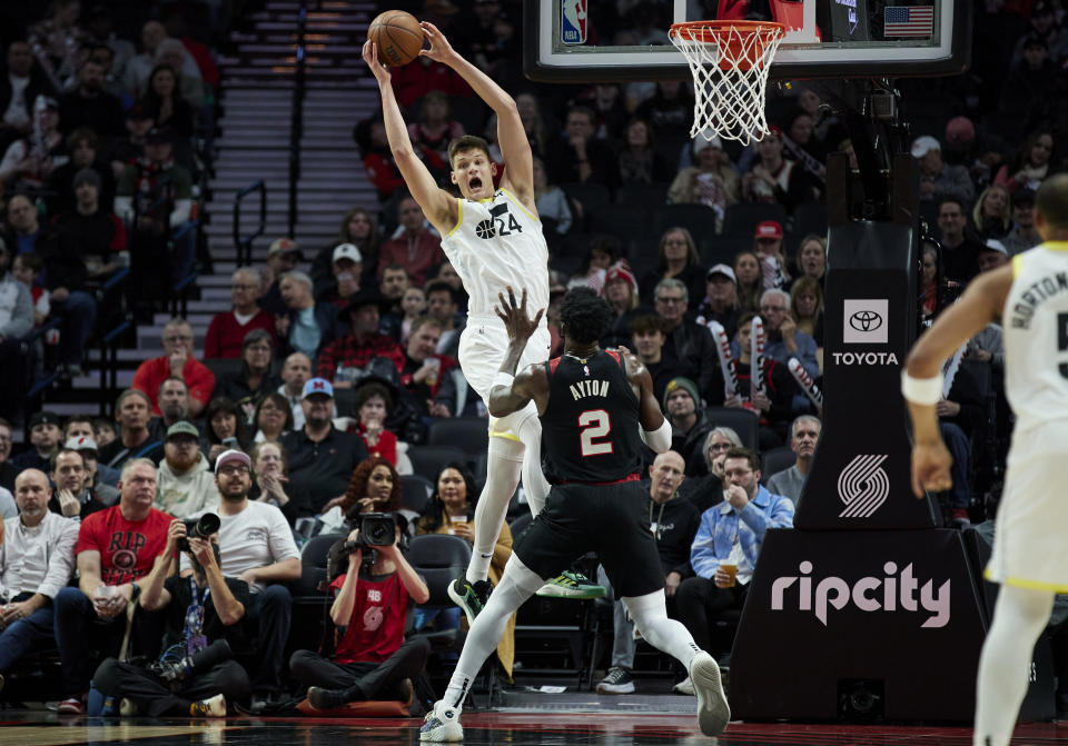 Utah Jazz center Walker Kessler, left, receives a pass in front of Portland Trail Blazers center Deandre Ayton during the first half of an NBA basketball game in Portland, Ore., Thursday, Dec. 14, 2023. (AP Photo/Craig Mitchelldyer)