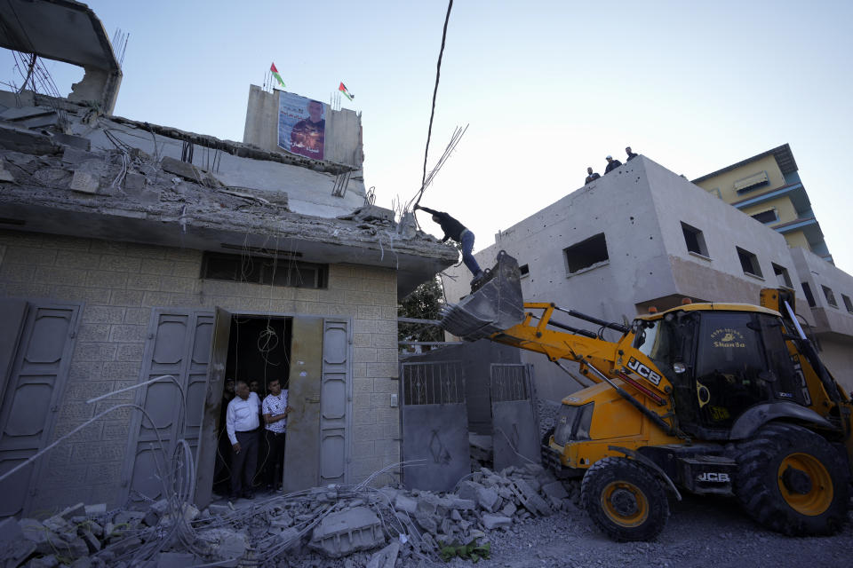 Palestinians inspect the damage to the house of Palestinian militant Diaa Hamarsheh that was demolished by Israeli troops in the West Bank village of Yabed, Thursday, June 2, 2022. Hamarsheh was shot and killed by Israeli police after he killed three Israelis and two Ukrainian citizens in a deadly shooting attack in Bnei Brak on March 29, 2021. Israeli officials say the demolitions deter future attacks, while rights groups view it as a form of collective punishment. (AP Photo/Majdi Mohammed)