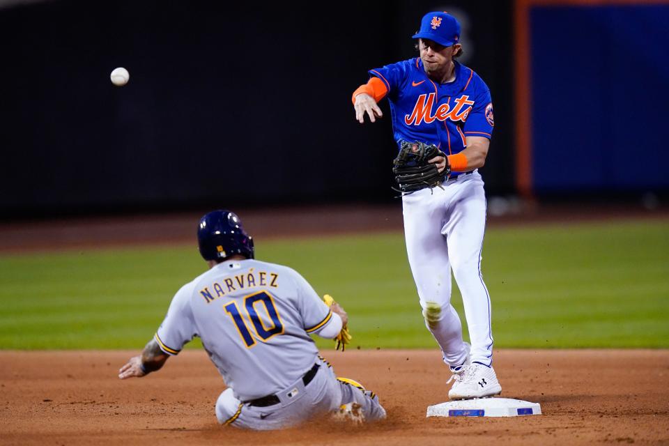 New York Mets' Jeff McNeil, right, throws to first base after being forced out by Milwaukee Brewers' Omar Narvaez (10) during the fourth inning of a baseball game on Thursday, June 16, 2022 in New York.  Hunter Renfroe was initially safe.  (AP Photo/Frank Franklin II)