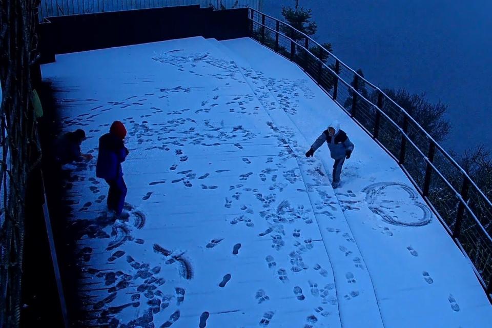 受寒流影響，桃園市復興區23日凌晨起多處相繼飄雪，許多遊客開心的到戶外賞雪，還童心大起打起雪仗。（圖／桃園市政府觀光旅遊局提供）