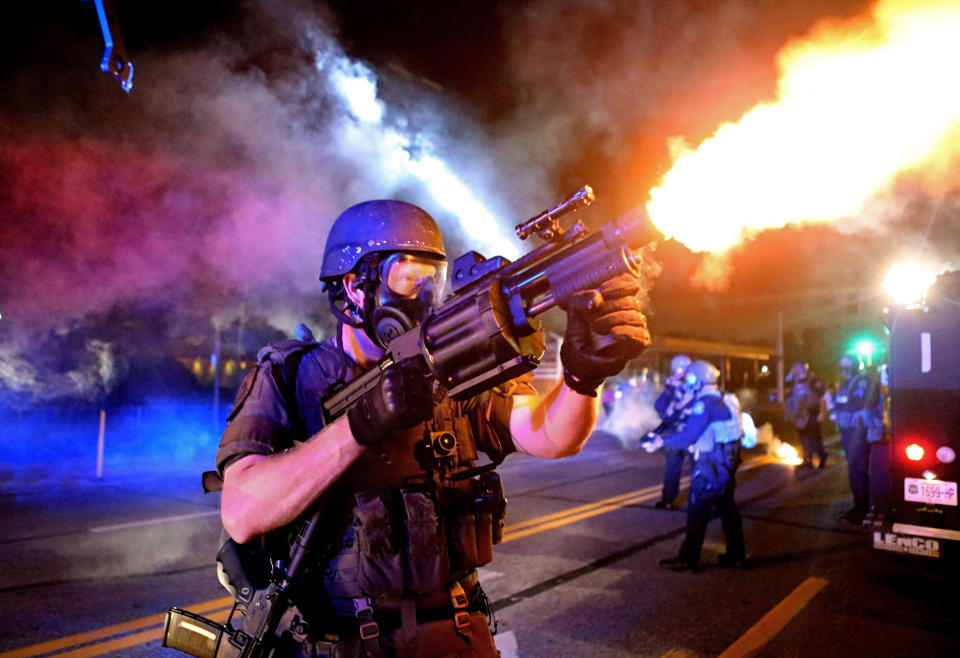 <p>A member of the St. Louis County Police tactical team fires tear gas into a crowd of people in response to a series of gunshots fired at the police during demonstrations along W. Florissant Road near the QuikTrip on August 18, 2014 in Ferguson, Missouri. Protesters also threw bottles and rocks with at least one rock striking an officer in the arm. Protesters and police clashed almost nightly for more than 2 weeks during the unrest that followed white police officer Darren Wilson shooting and killing unarmed 18-year-old Michael Brown. (David Carson/St Louis Post-Dispatch/ZUMAPRESS.com) </p>