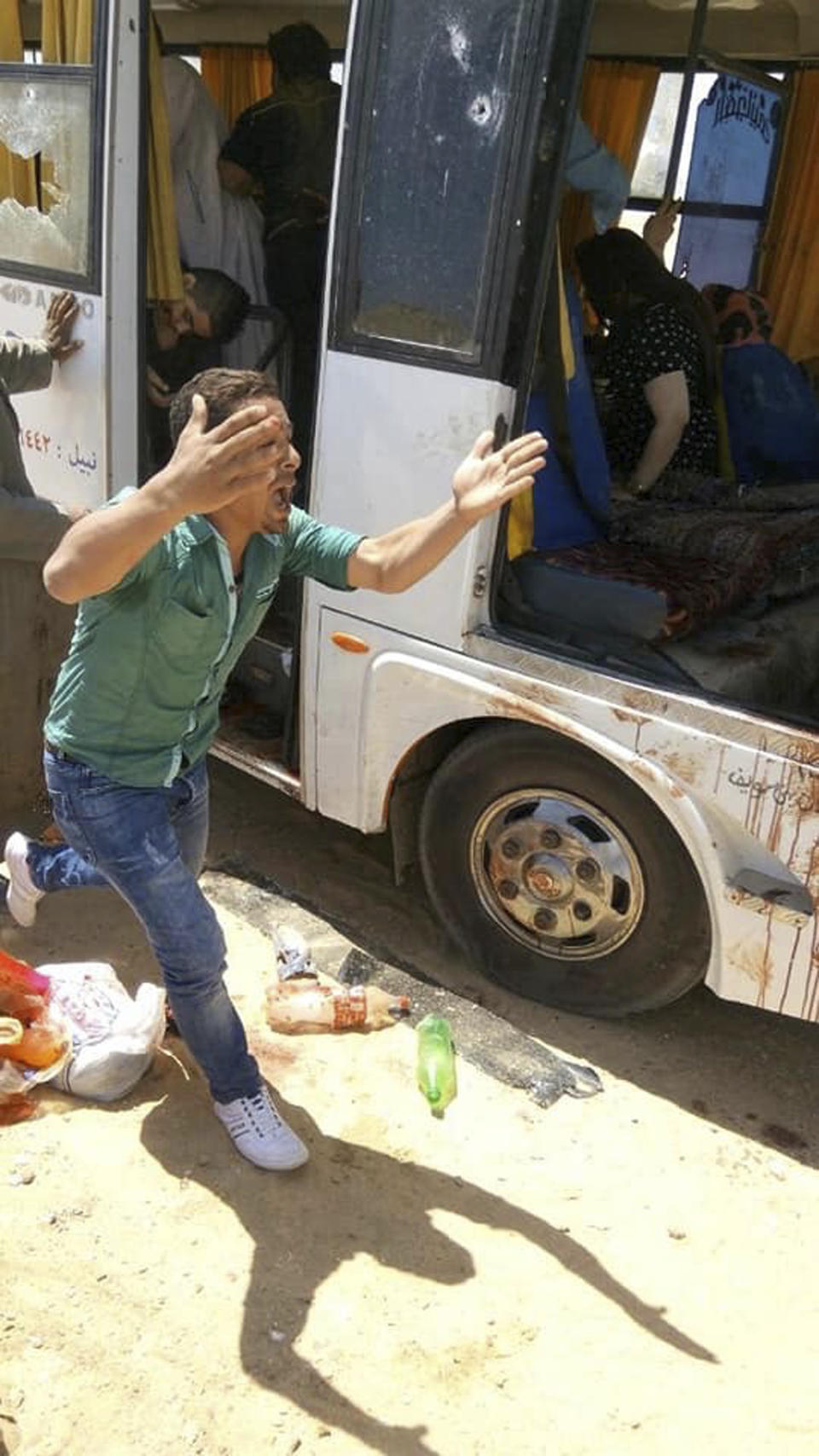 A man screams beside a bus carrying Coptic Christians which came under attack outside Cairo, Friday, Nov. 2, 2018. Islamic militants on Friday ambushed a bus carrying Christian pilgrims on their way to a remote desert monastery south of the Egyptian capital, killing at least seven and wounding a dozen more, the Interior Ministry said.(Egypt’s Coptic Orthodox Church via AP)