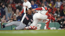 Cleveland Guardians' José Ramírez, left, scores on a single by Estevan Florial, next to Boston Red Sox's Connor Wong during the 11th inning of a baseball game Tuesday, April 16, 2024, in Boston. (AP Photo/Steven Senne)