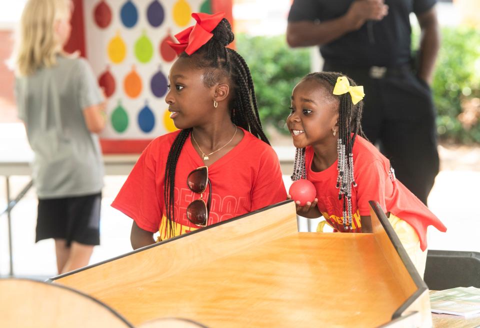 Kamryn, 8, and Kyndal, 4, Witherspoon play games during the Rosa Parks Museum Annual Juneteenth celebration in Montgomery, Ala., on Saturday, June 18, 2022.