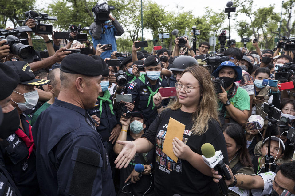 FILE - In this Sept. 20, 2020, file photo, one of the pro-democracy student leaders negotiates with police officials as they march on road during a protest in Bangkok, Thailand. Fed up with an archaic educational system and enraged by the military's efforts to keep control over their nation, a student-led campaign has shaken Thailand’s ruling establishment with the most significant campaign for political change in years. (AP Photo/Wason Wanichakorn, File)