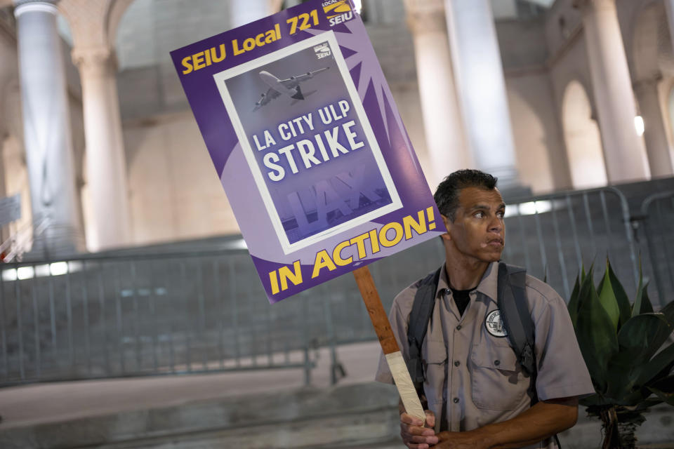 A Los Angeles city employee holds up a sign with SEIU Local 721 as he pickets outside of City Hall in Los Angeles on Tuesday, Aug. 8, 2023. Thousands of Los Angeles city employees, including sanitation workers, engineers and traffic officers, walked off the job for a 24-hour strike alleging unfair labor practices. The union said its members voted to authorize the walkout because the city has failed to bargain in good faith and also engaged in labor practices that restricted employee and union rights. (David Crane/The Orange County Register via AP)