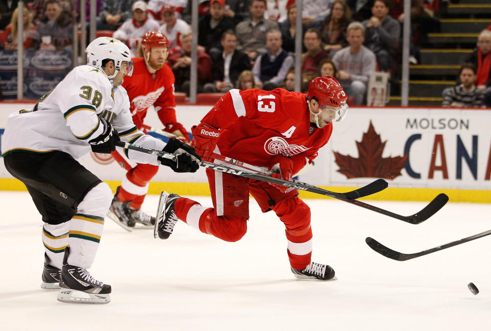 DETROIT, MI - FEBRUARY 14: Pavel Datsyuk #13 of the Detroit Red Wings tries to control the puck in front of Vernon Fiddler #38 of the Dallas Stars at Joe Louis Arena on February 14, 2012 in Detroit, Michigan. Detroit defeated Dallas 3-1. The win set a NHL record for the most consecutive home victories with 21. (Photo by Gregory Shamus/Getty Images)