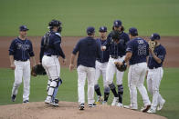 Tampa Bay Rays starting pitcher Tyler Glasnow, third from right, hands over the baseball to manager Kevin Cash during the third inning in Game 5 of the baseball team's AL Division Series against the New York Yankees, Friday, Oct. 9, 2020, in San Diego. (AP Photo/Jae C. Hong)
